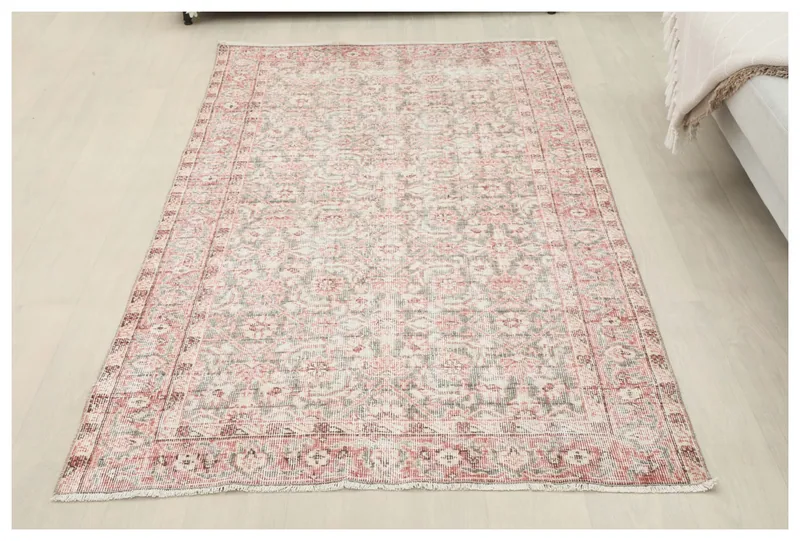 Full top view of the 4x7 rose and gray vintage Anatolian rug on a white background