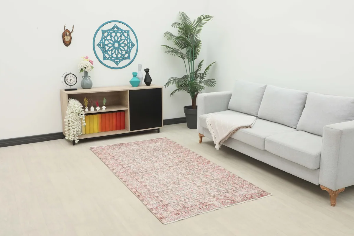 Vintage rose and gray rug placed in a modern living room setting with a light gray sofa