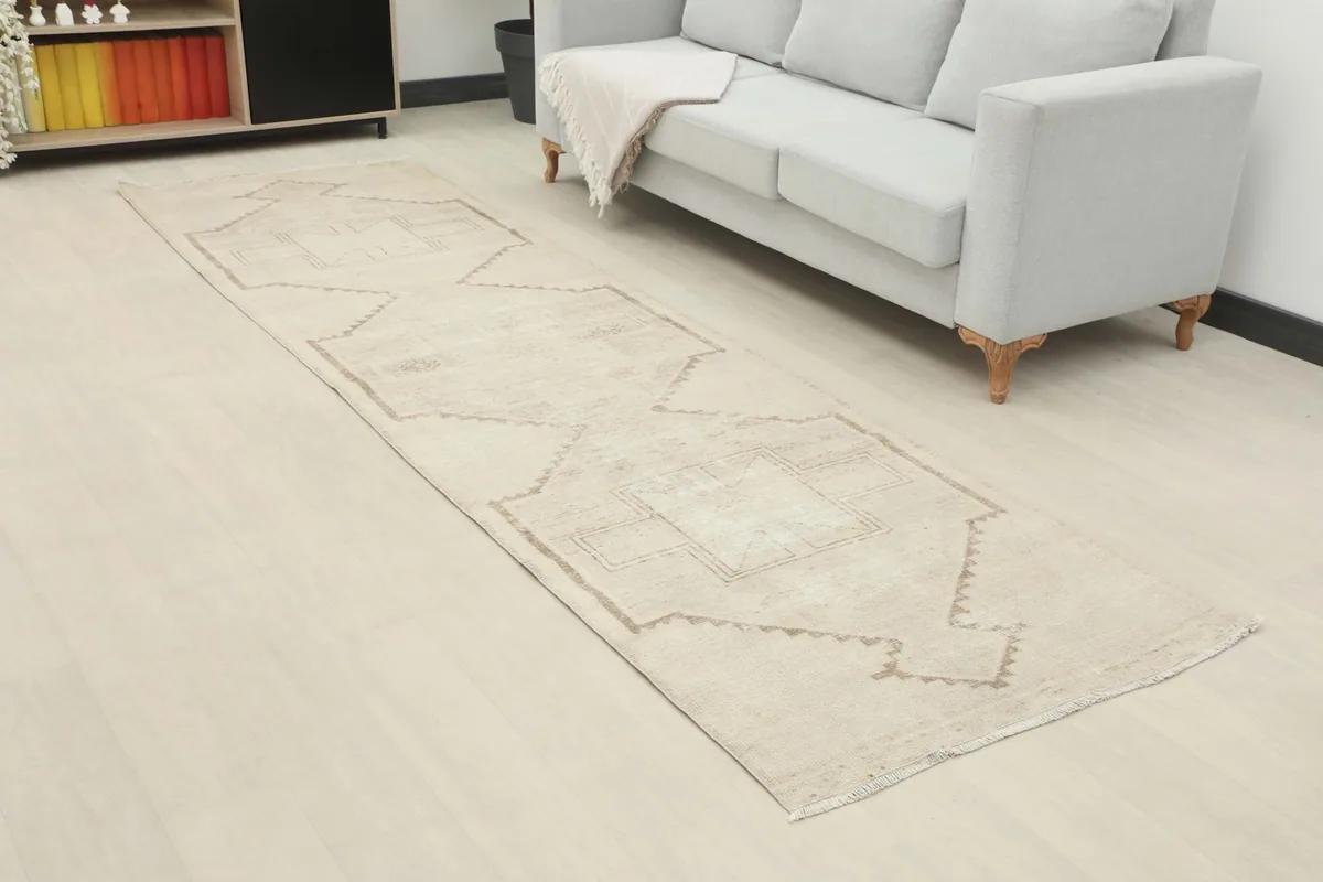 Angle view of the ivory geometric runner extending through a room next to a sofa