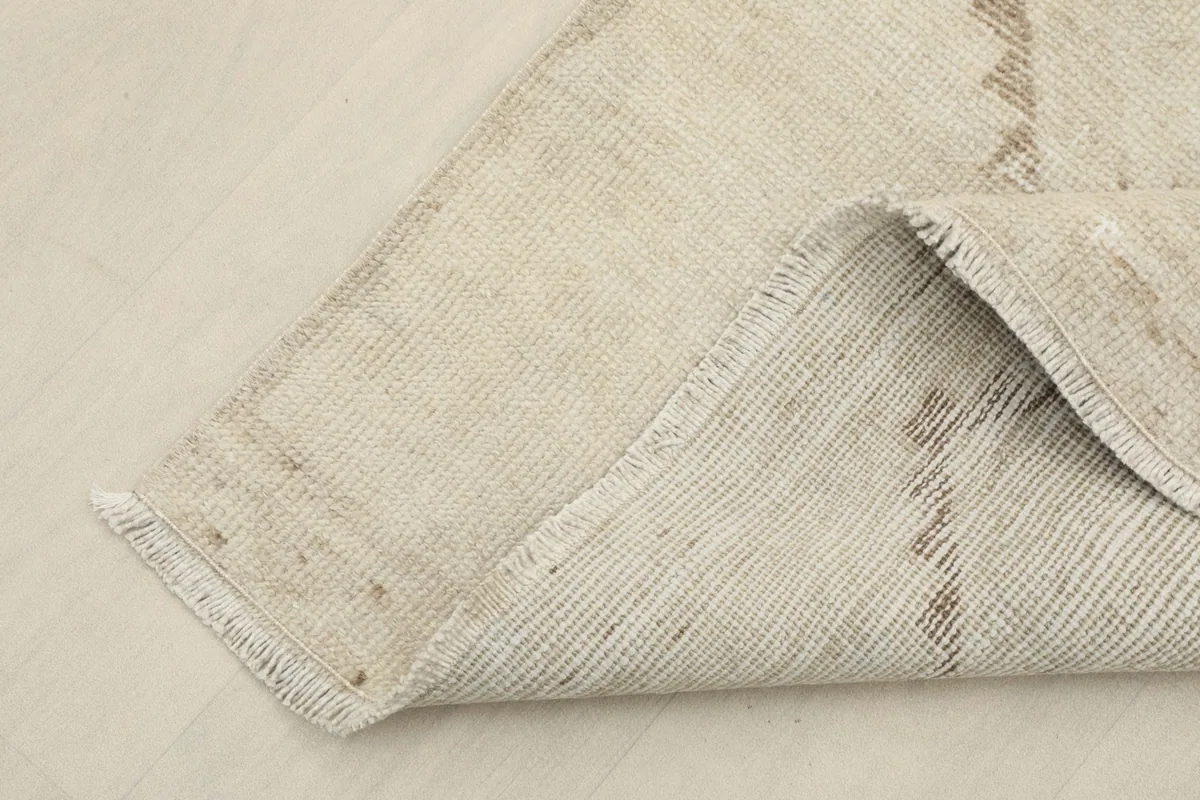 Corner of the runner folded back, revealing the wool pile and cotton foundation