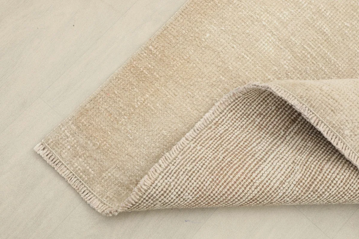 Corner view showing the back of the hand-knotted rug and the cotton foundation