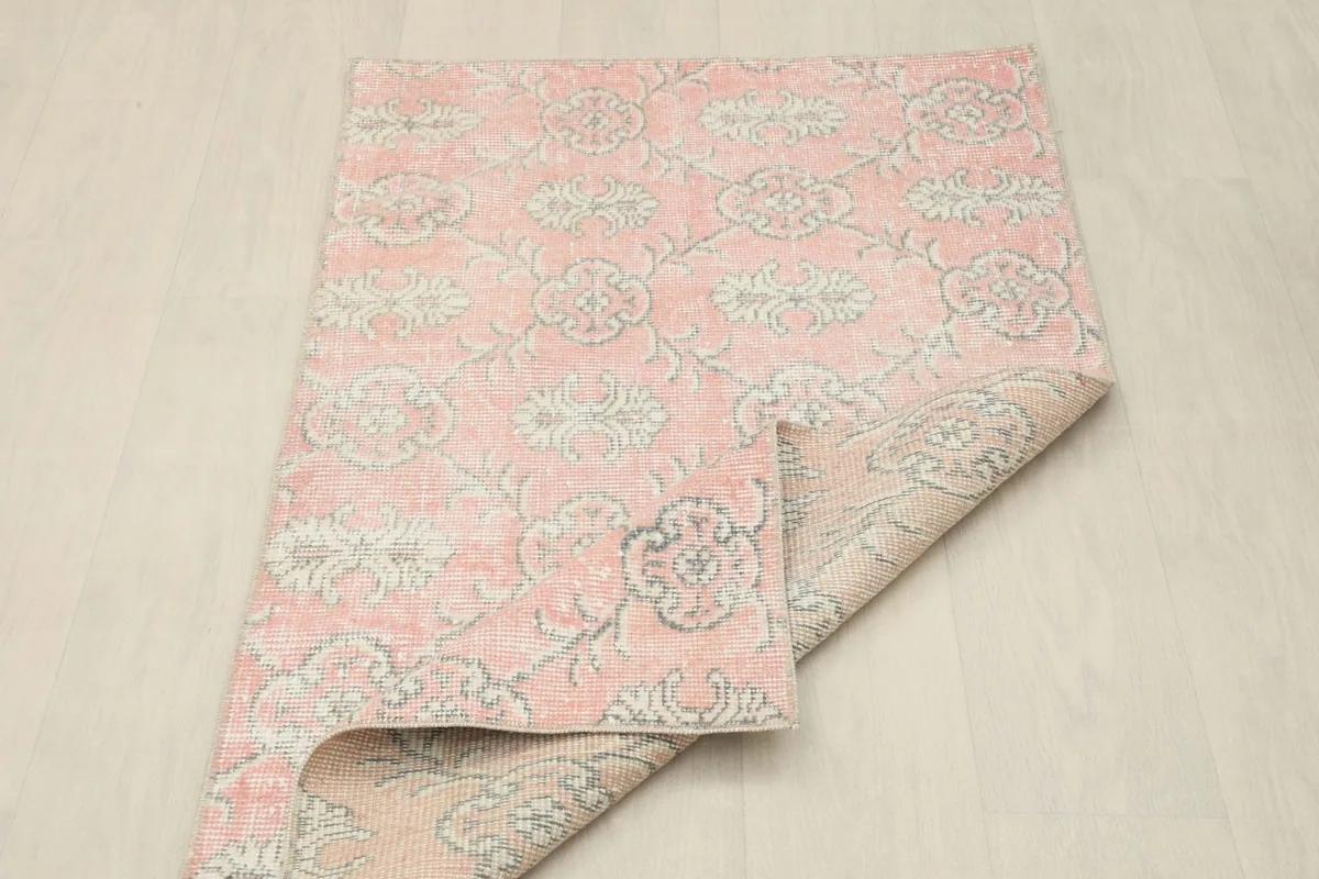 Rug partially folded, showcasing the flexibility and texture of the vintage hand-knotted material.