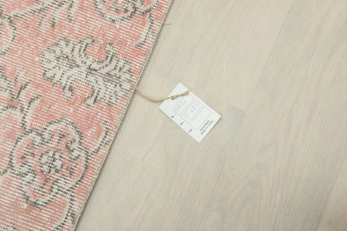 Rug with a product tag near its edge, indicating quality and origin details.