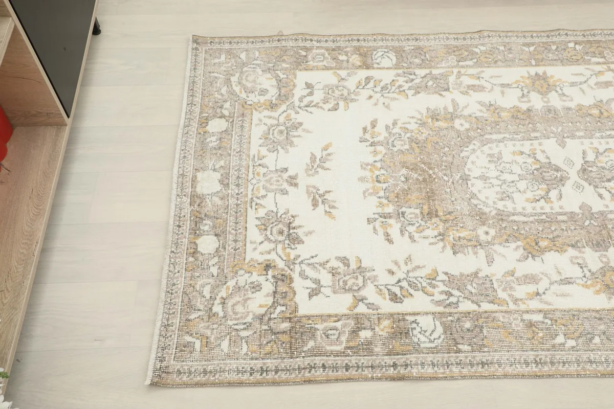Overhead angled shot highlighting the floral motifs and colors of the rug