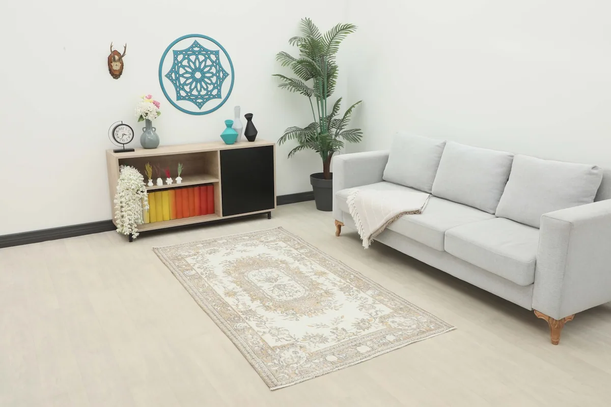 Ivory beige floral rug placed in a modern living room setting with a light sofa
