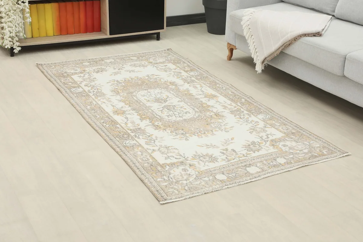Angled view of the ivory beige rug in a room, showing its placement near a sofa