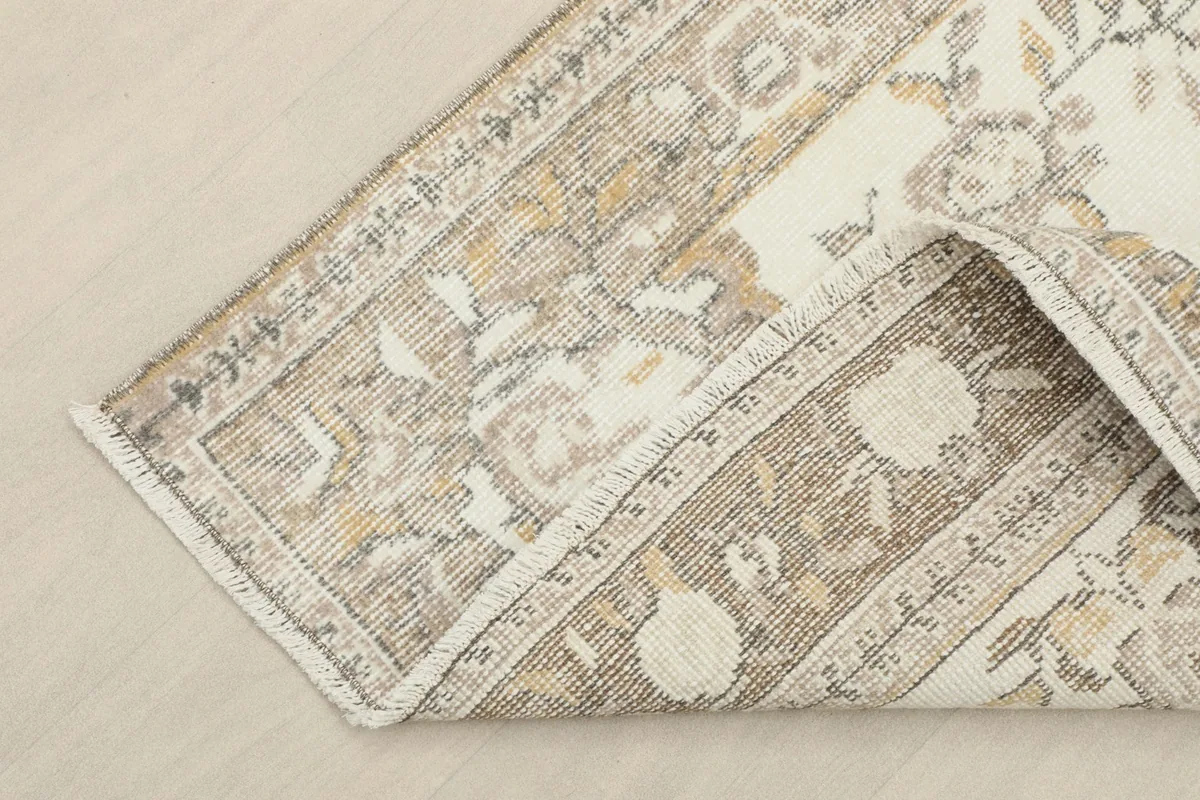 Corner of the rug folded back, showing the cotton foundation and construction