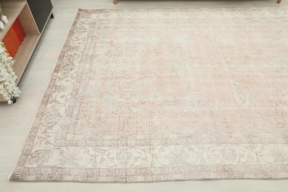 Another angled view of the large area rug, emphasizing the intricate border design and muted colors.