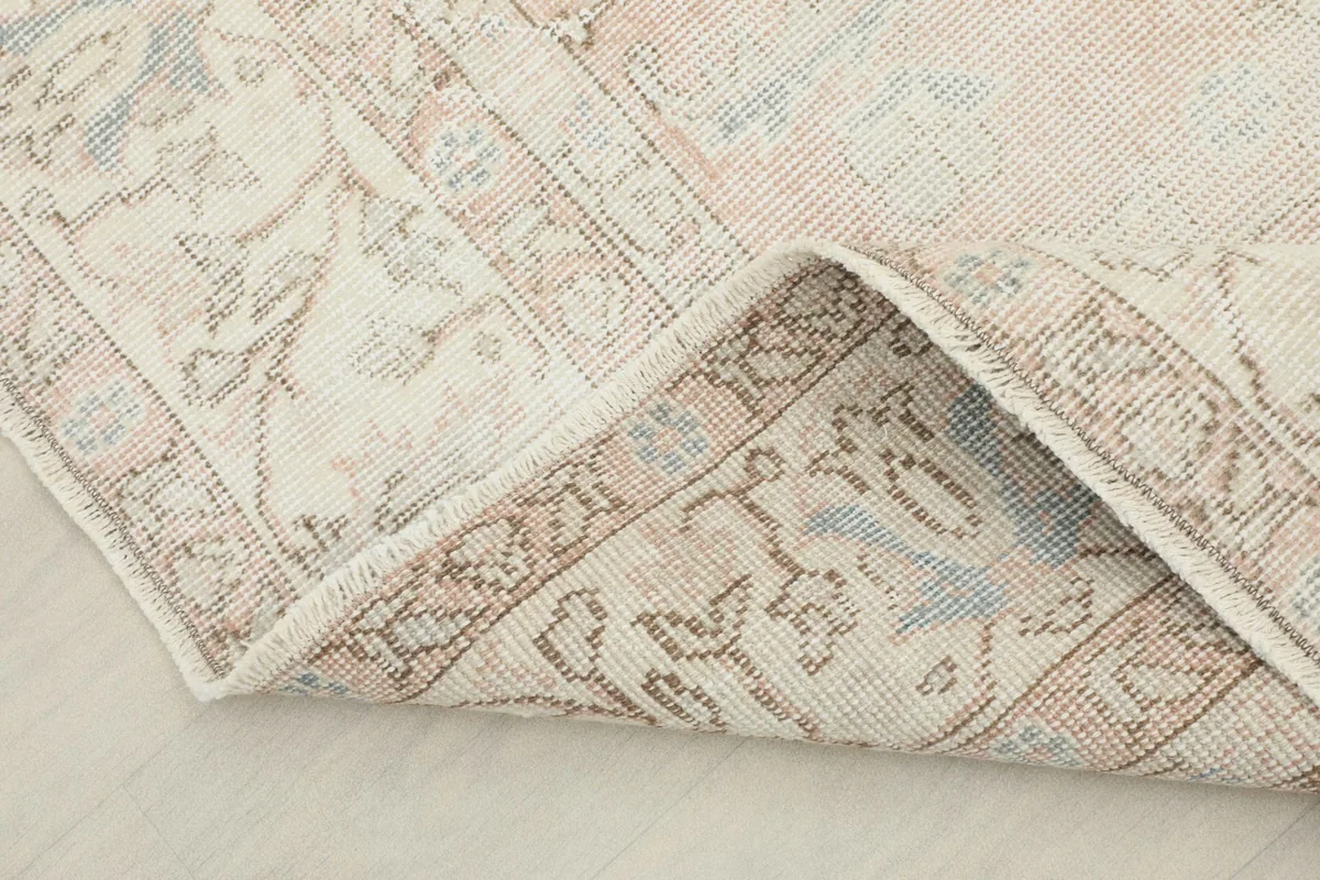 Folded corner of the rug, illustrating the thickness and flexibility of the hand-knotted wool on cotton.