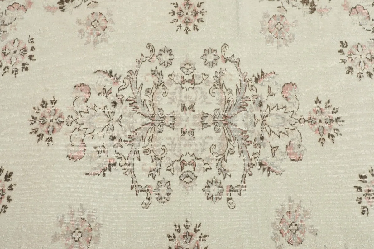 Close-up of the central medallion and surrounding floral motifs on the ivory field
