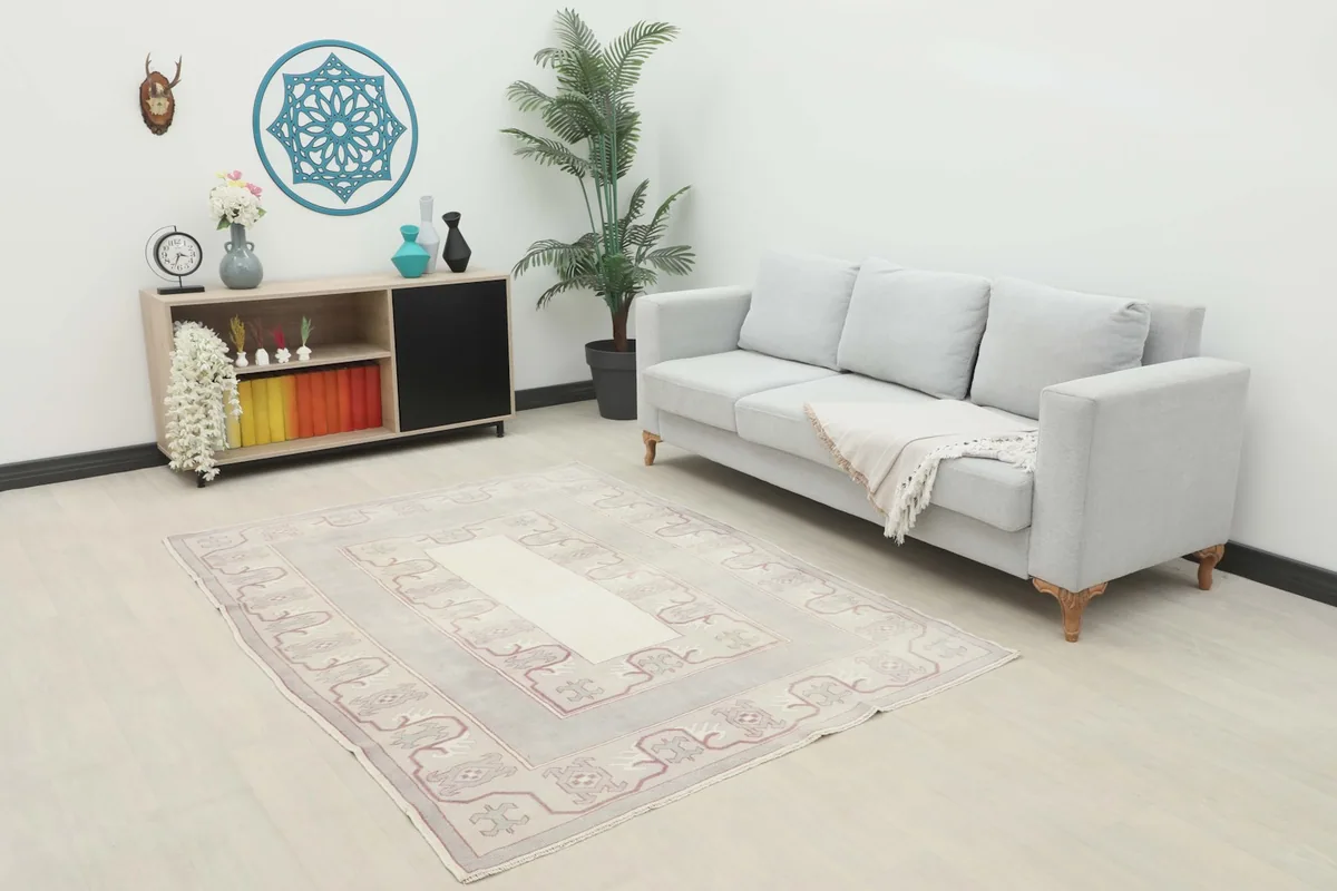 Rose Gray Geometric Rug placed in a living room setting with a light gray sofa