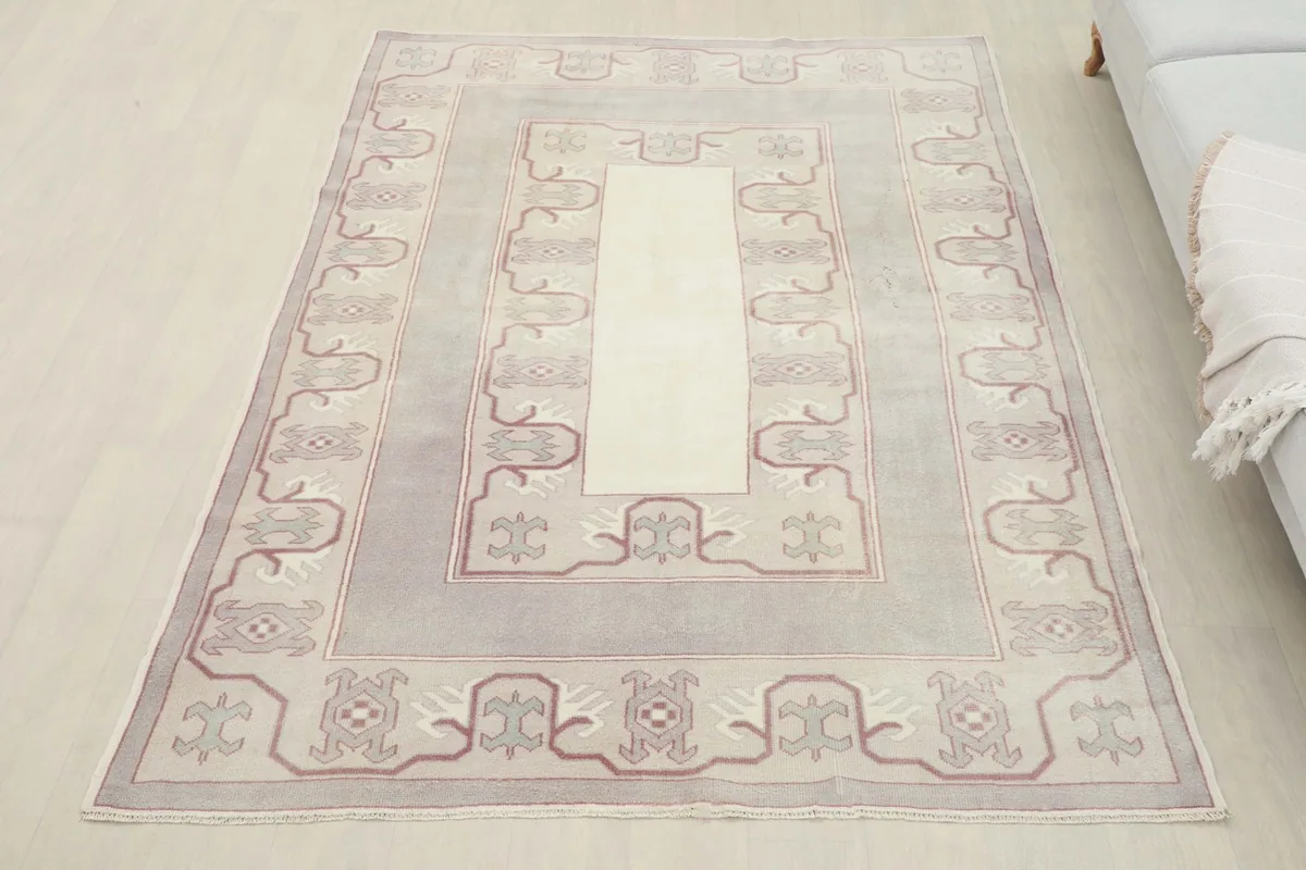 Overhead view of the Rose Gray Geometric Rug in a room, next to a light gray sofa