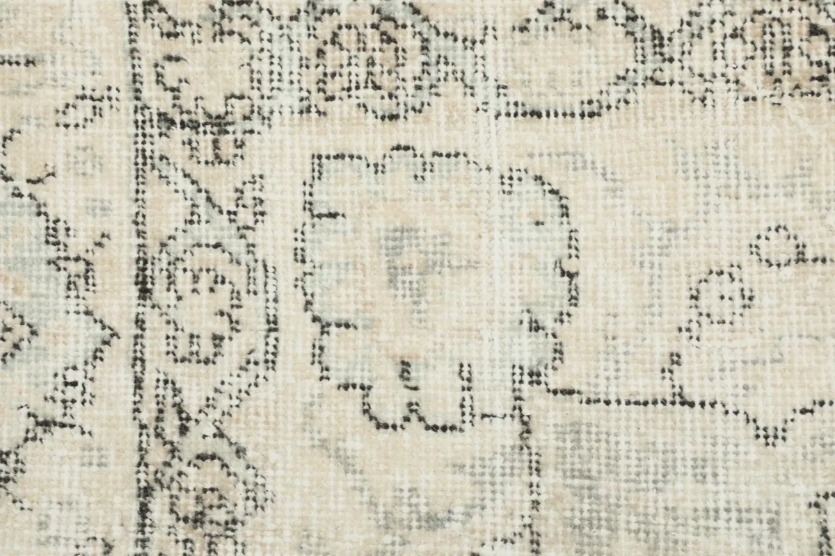 Detailed view of the hand-knotted wool pile, showing the texture and intricate gray patterns.