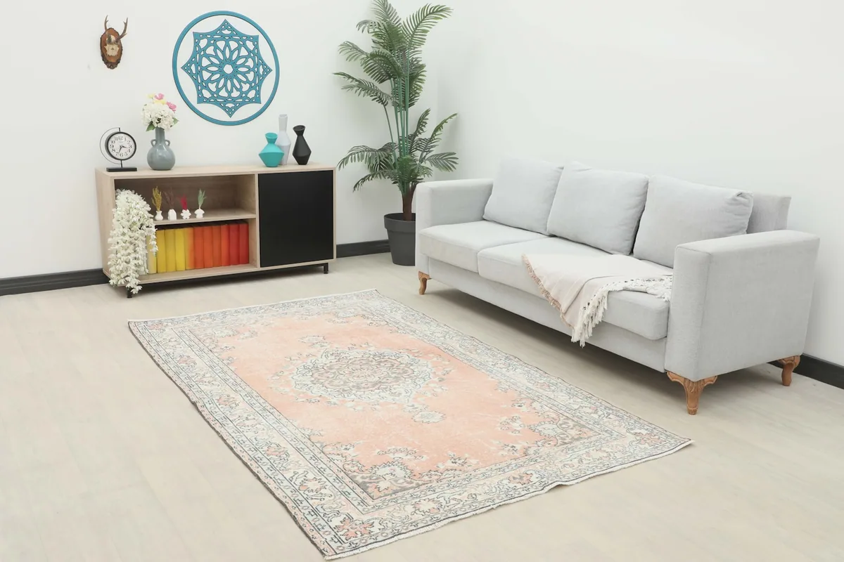 Rose vintage Anatolian rug in a living room setting with a light gray sofa