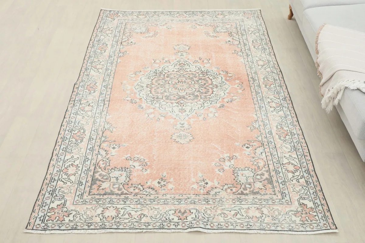 Full view of the rose vintage Anatolian rug placed in a room setting