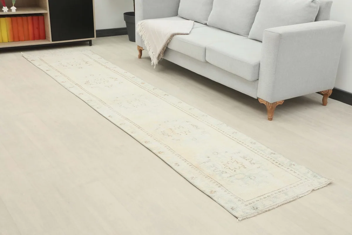 Vintage runner displayed in a contemporary living space next to a light gray sofa and modern shelving.