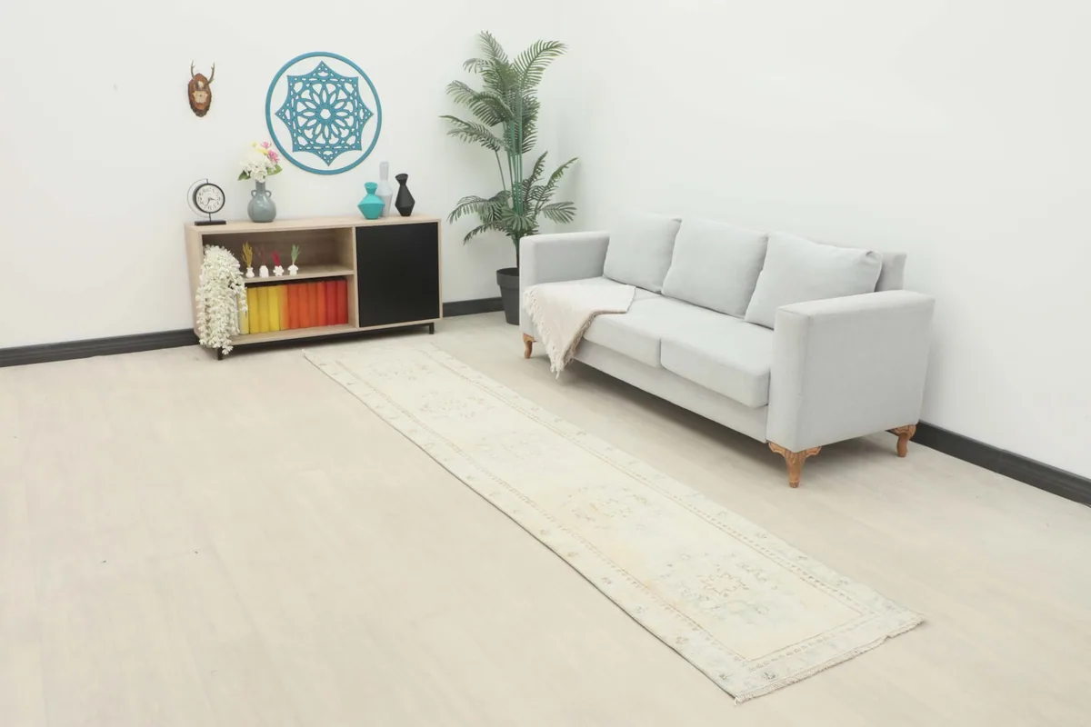 Full room view with the cream runner extending from a gray sofa, adding warmth to the modern decor.