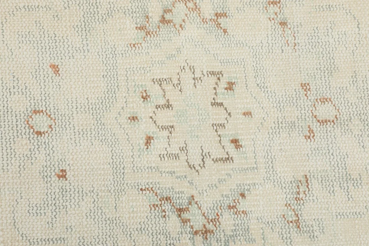 Detailed shot of a central geometric medallion motif, showing the colors and hand-knotted texture.