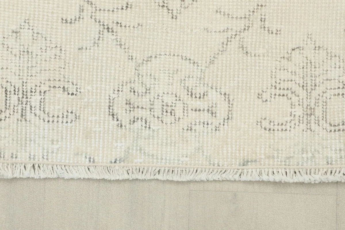 Close-up of the rug's edge showing the short fringe and the low wool pile