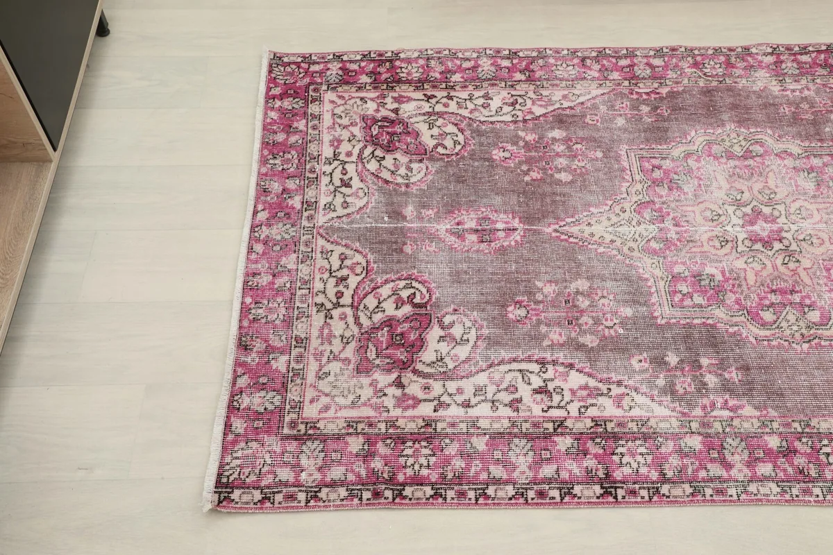 Detailed angle of the rug's border and main field with floral and medallion patterns