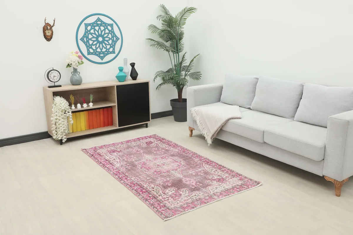 Vintage Anatolian area rug placed in a living room setting with a light gray sofa