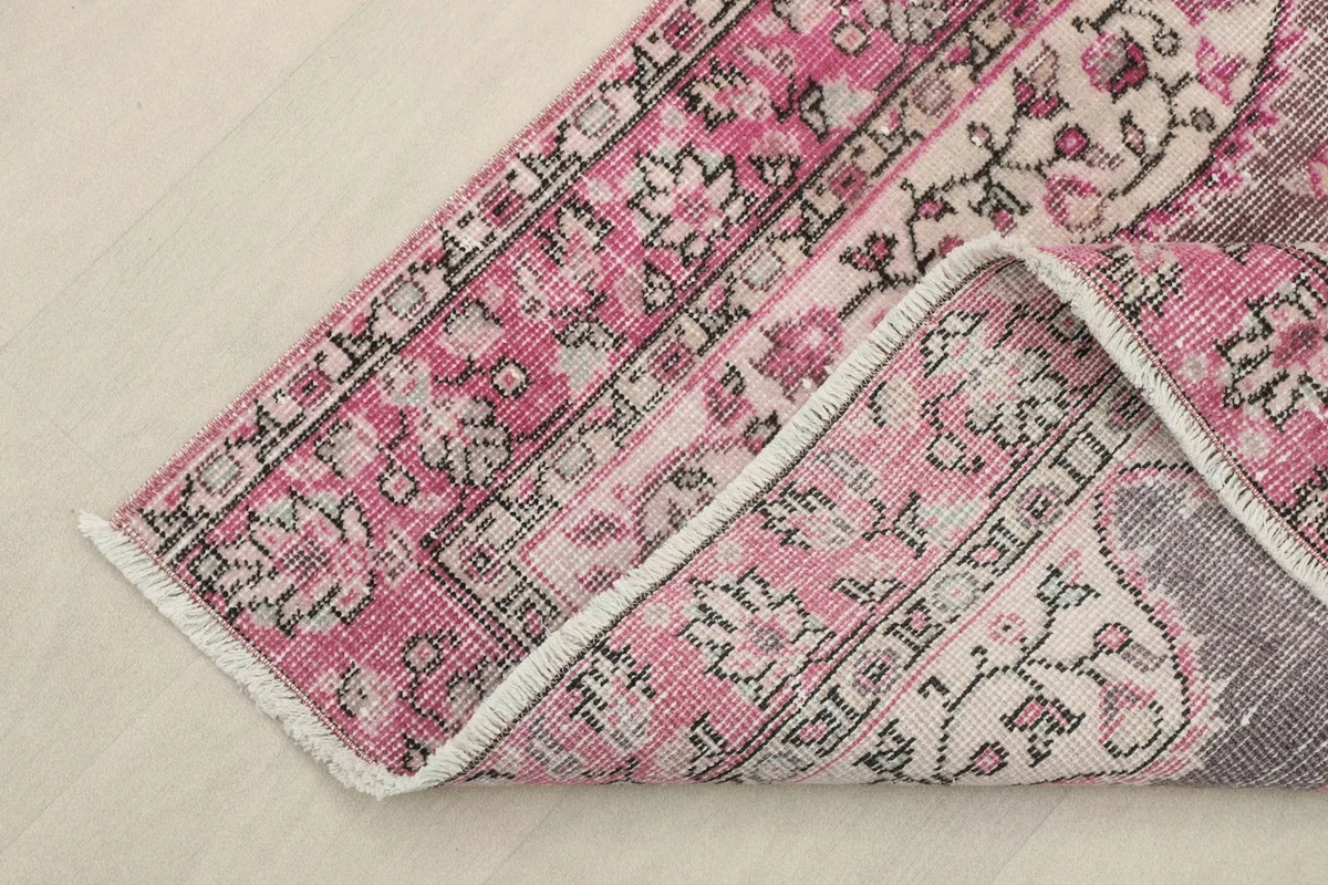Corner of the vintage rug folded back, revealing the cotton foundation