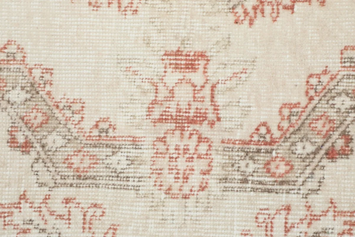 Close-up of the hand-knotted wool pile and faded rose and gray colors