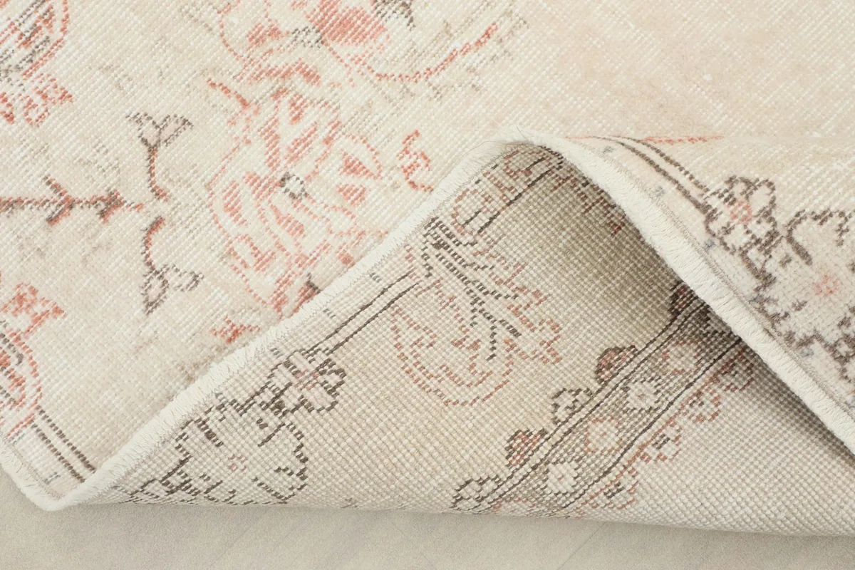 Corner of the rug folded to reveal the cotton foundation and reverse side