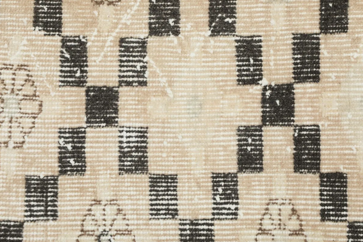 Close-up of the low wool pile and visible texture of the hand-knotted vintage rug.
