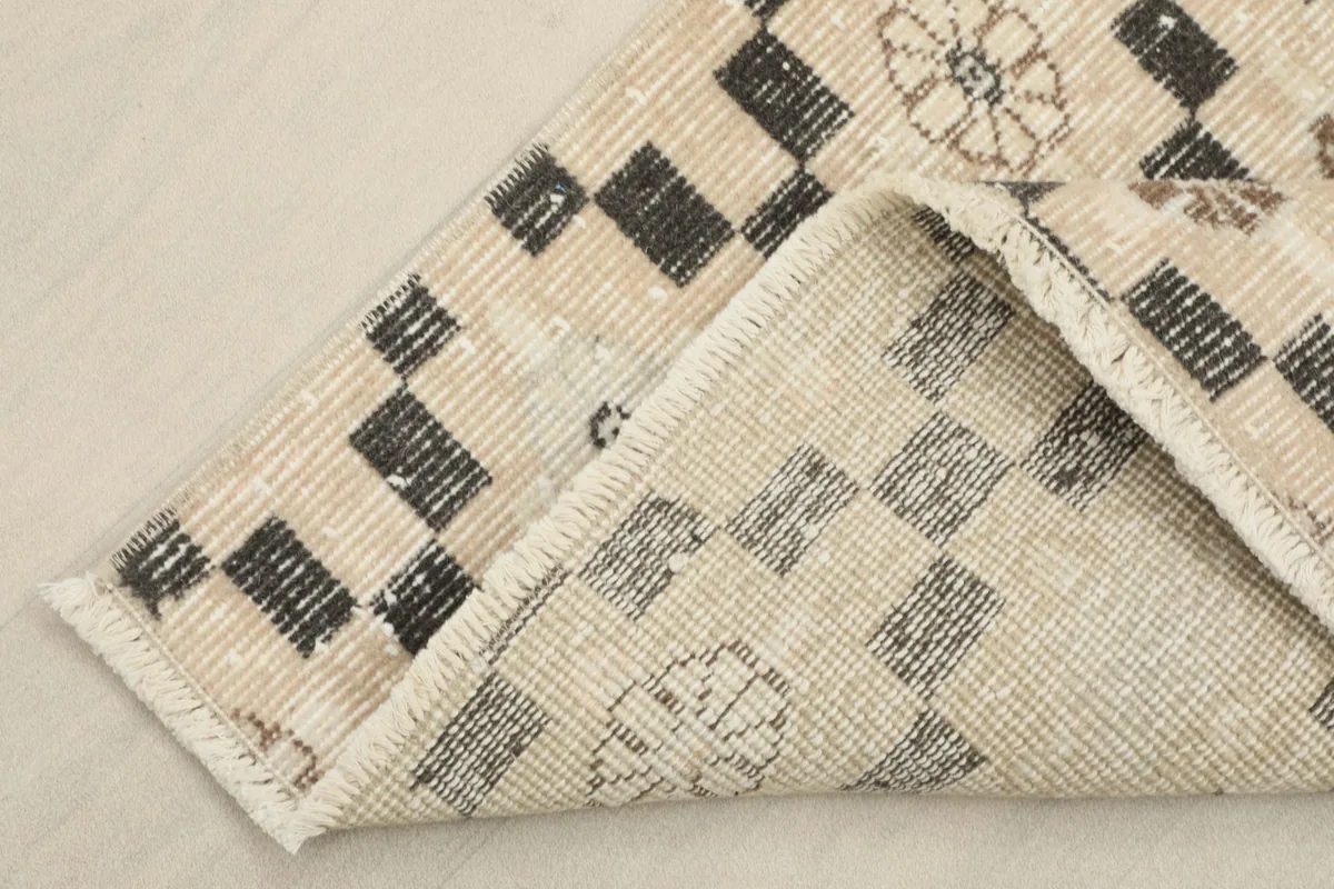 View of the rug's underside, revealing the cotton foundation and hand-knotted construction.