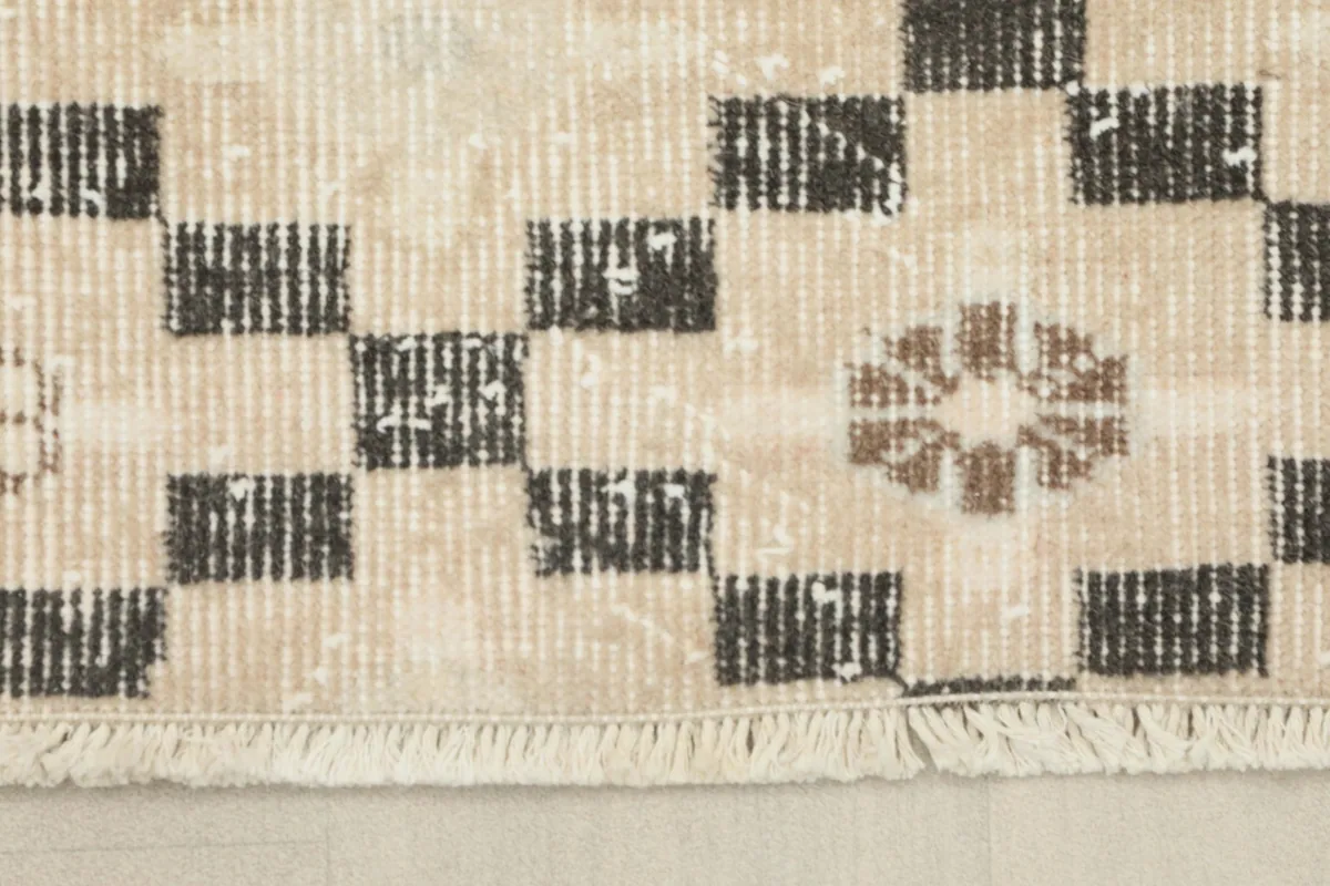 Detail of the rug's fringe and the texture of the low wool pile, showing the hand-knotted craftsmanship.