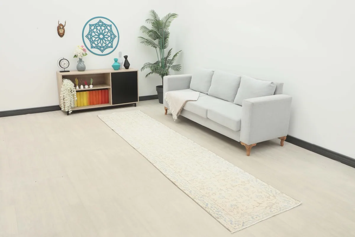 Vintage Anatolian runner rug displayed in a bright living space with a light sofa.