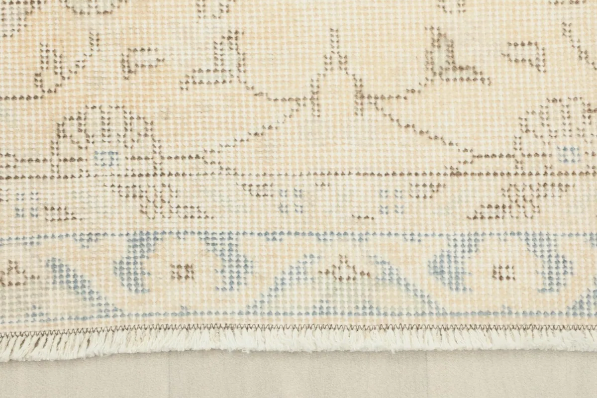 Close-up of the rug's end, showing the short, natural cotton fringe and border pattern.