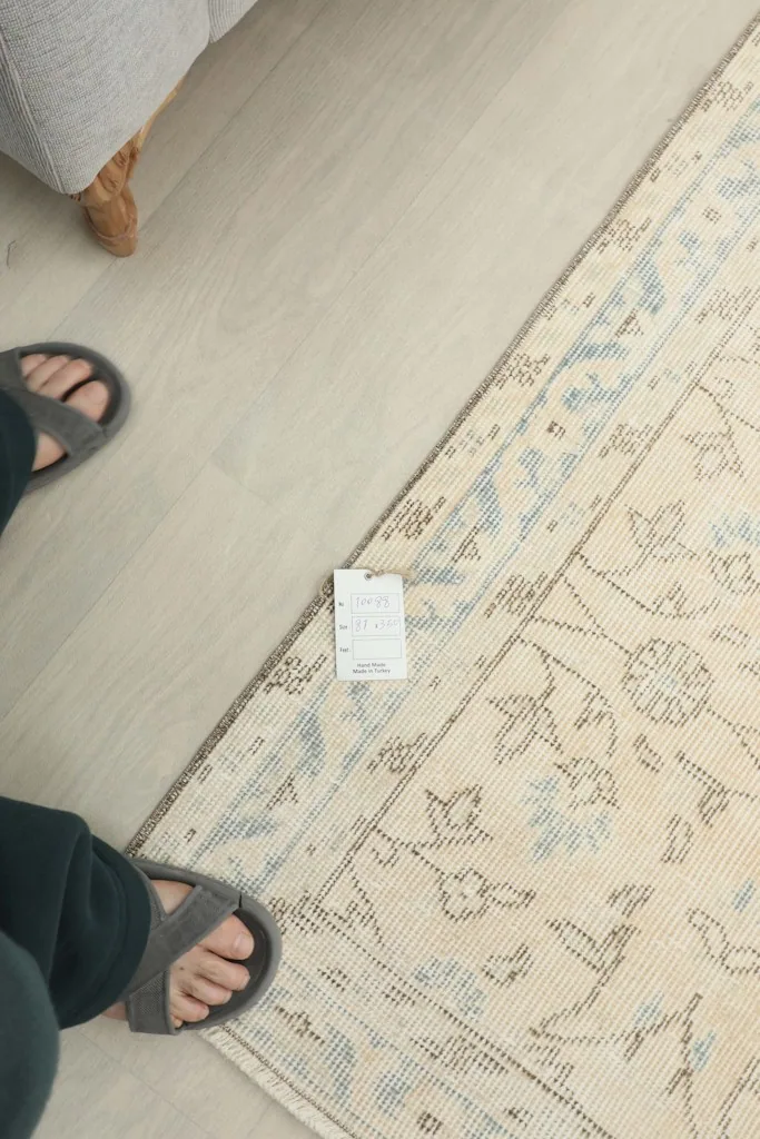 Feet next to the runner rug, indicating its scale and showcasing the texture and colors.