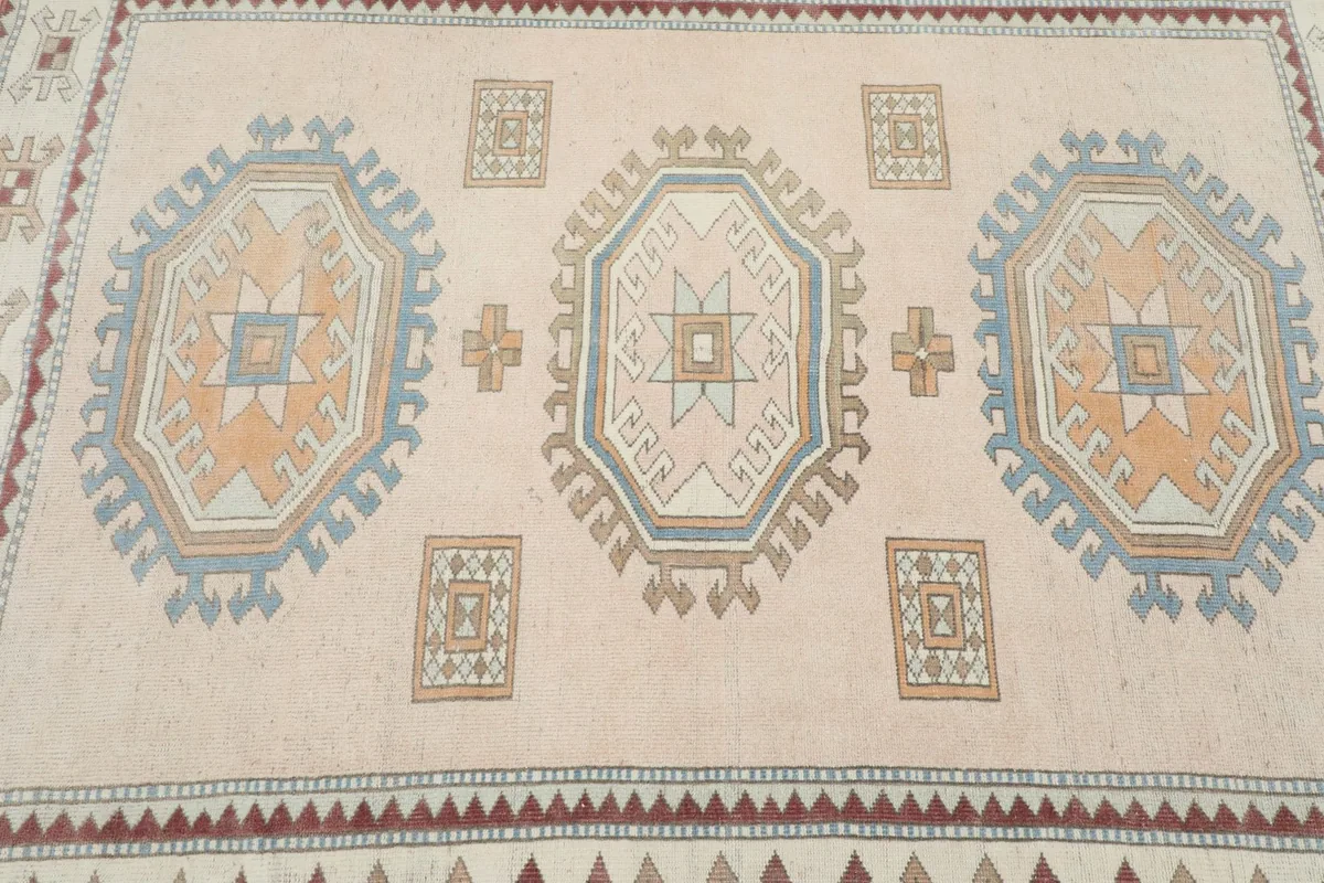 Detailed view of the central orange and blue medallions on the beige field.