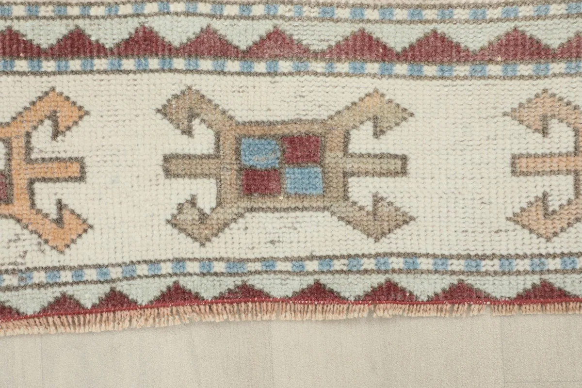 Detailed view of the outer border with rust, blue, and ivory tribal patterns.