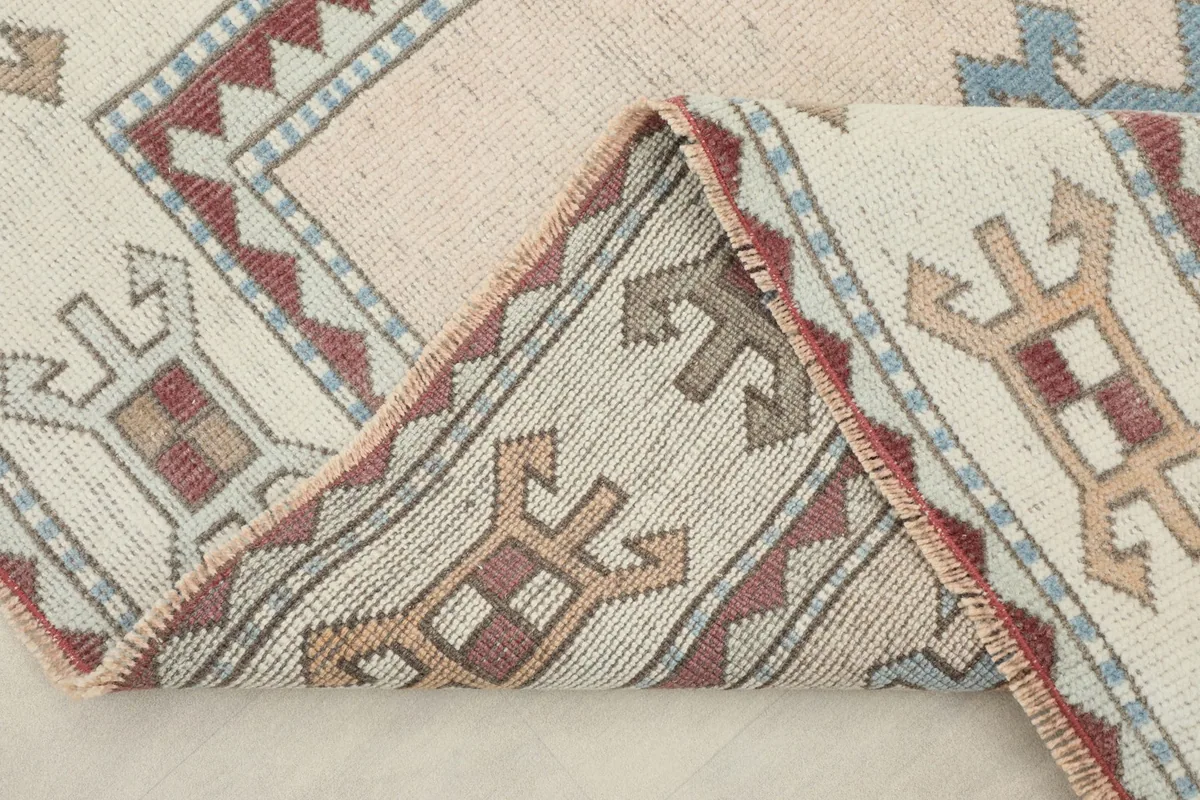 View of the rug folded to show the wool pile and cotton foundation.