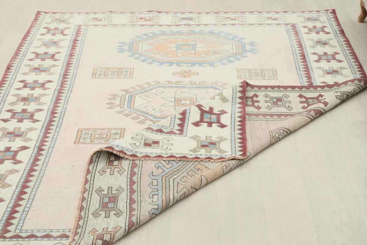 Partially folded rug displaying the back of the hand-knotted construction.