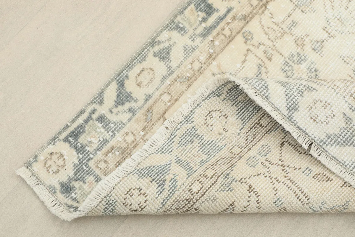 Corner of the runner folded to reveal the cotton foundation and the reverse side of the hand-knotted weave.