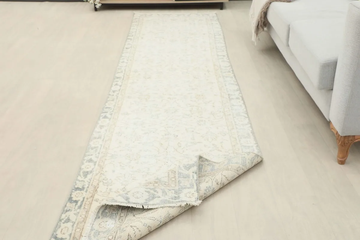 The runner partially folded, showing the flexibility and thickness of the vintage hand-knotted wool rug.