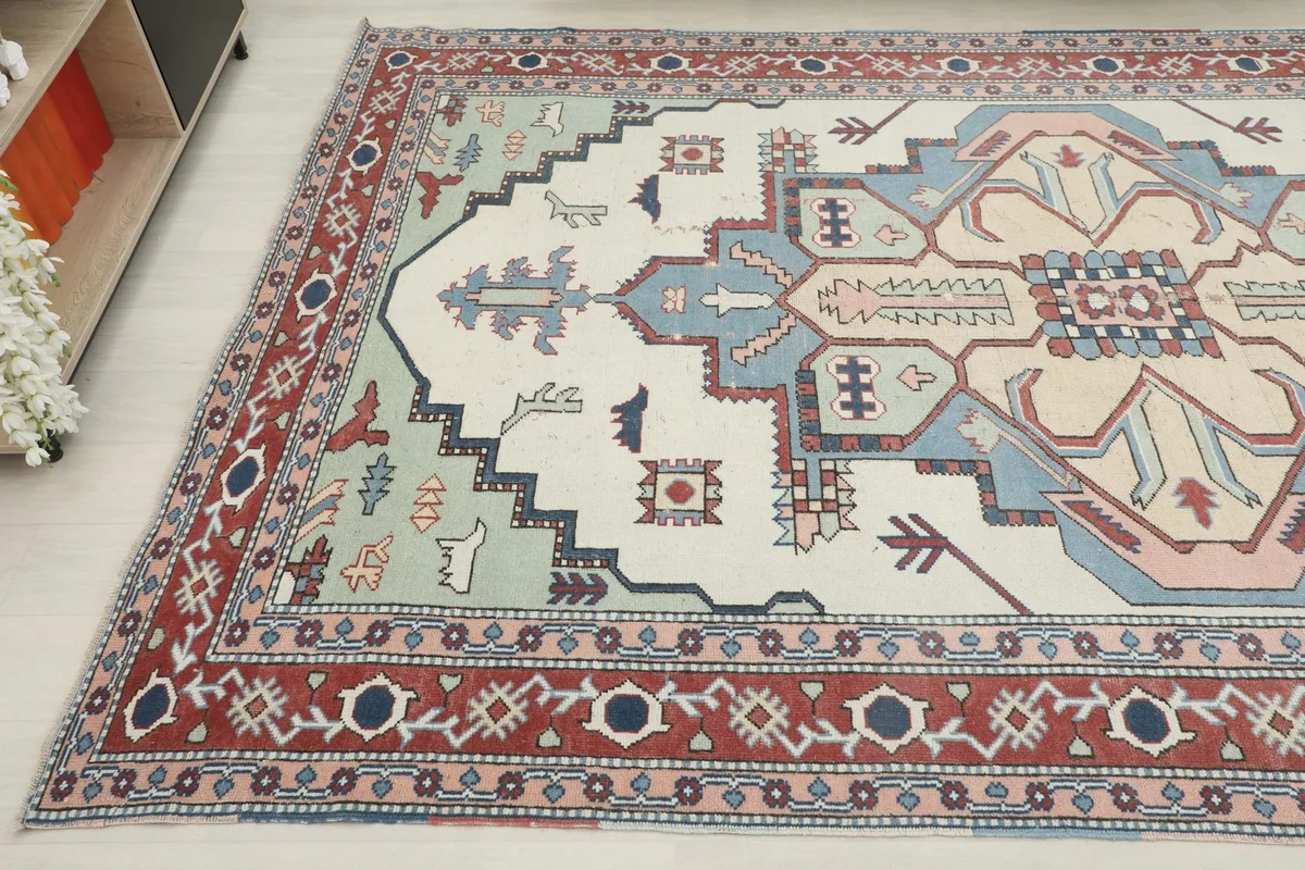 Angled view showcasing the full width of the vintage rug's geometric patterns