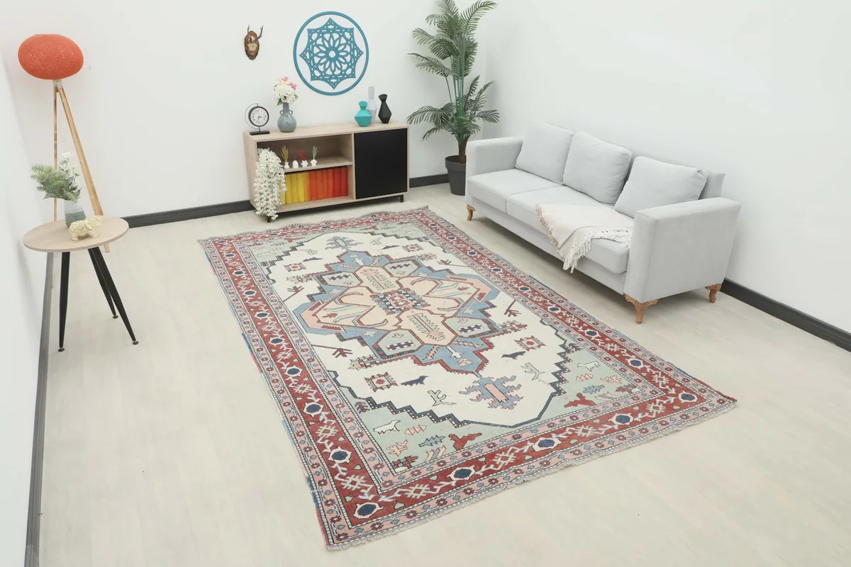 Vintage rug with ivory field and red border in a modern living room setting