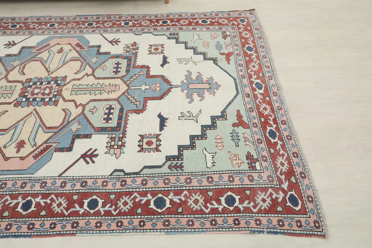 Close-up of the rug's corner, highlighting the red border and inner pink band