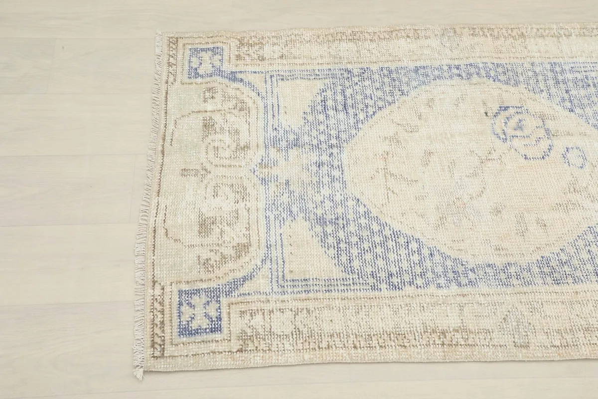 Close-up of the upper left section of the rug, highlighting the worn pile and patterns