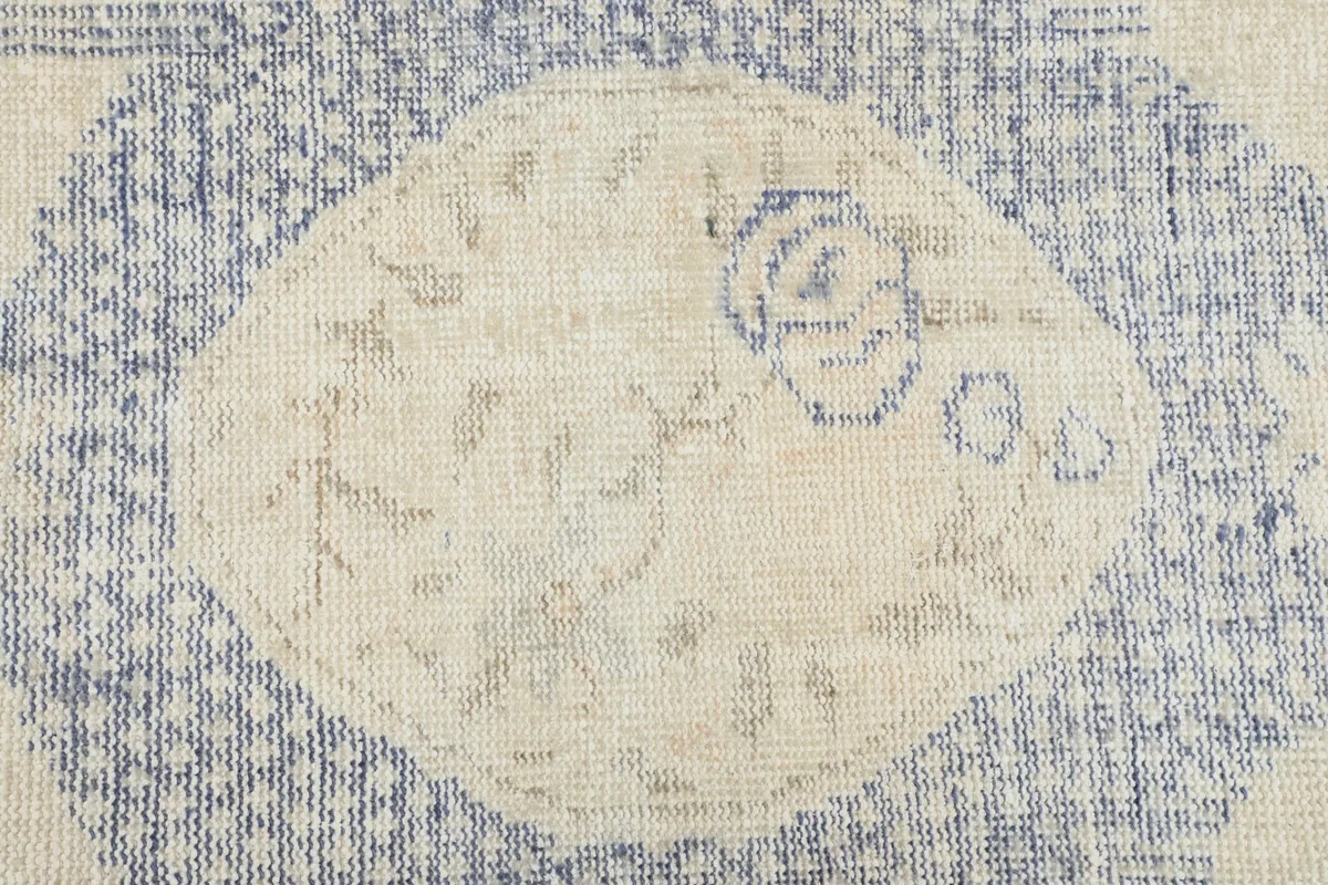 Detailed view of the central cream medallion with subtle blue motifs