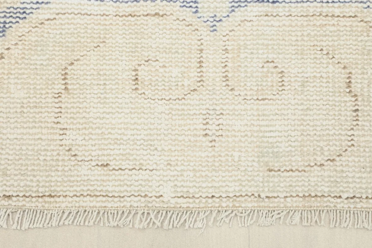 Close-up of the rug's bottom border and natural fringes, showing texture