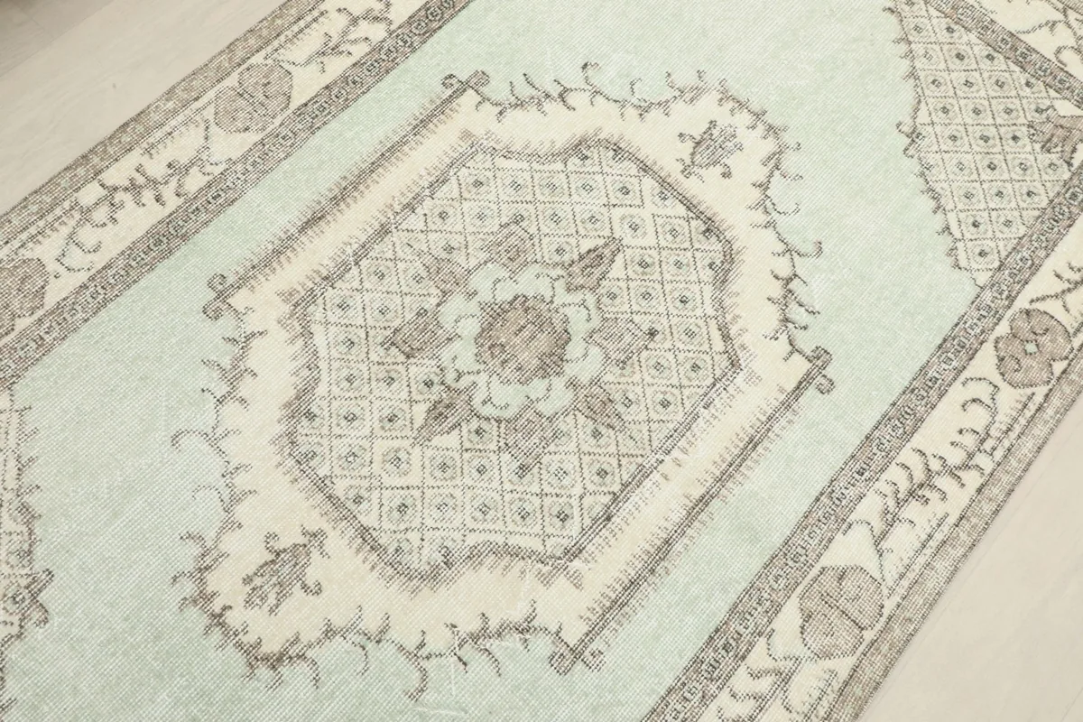 Angled view focusing on the central medallion and surrounding field patterns of the rug