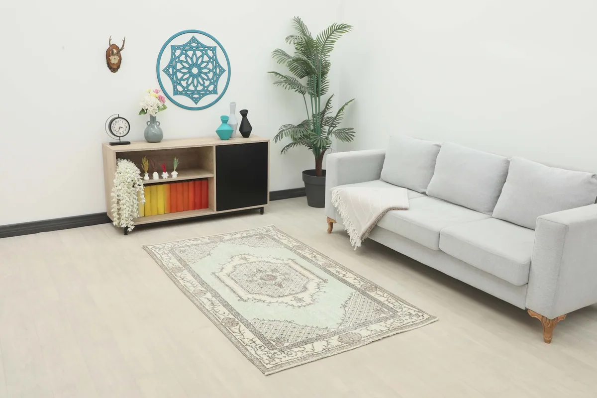 Vintage Anatolian rug displayed in a modern living room setting with a light gray sofa