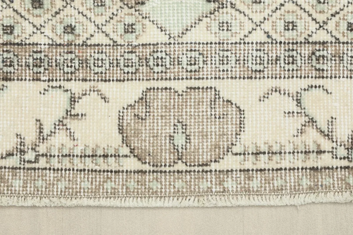 Close-up detail of the rug's border and fringe, showing the hand-knotted texture