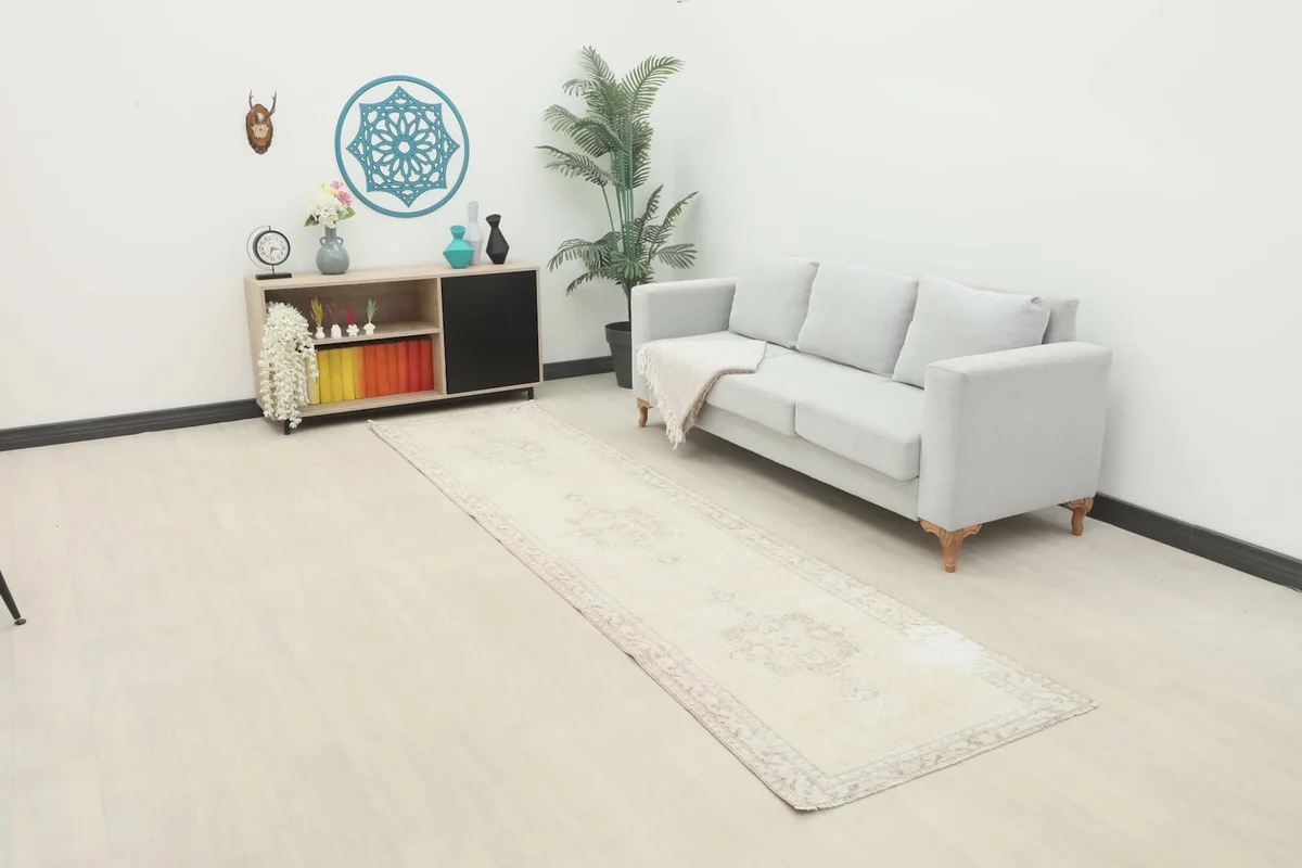 Vintage cream runner rug displayed in a bright room with a light gray sofa